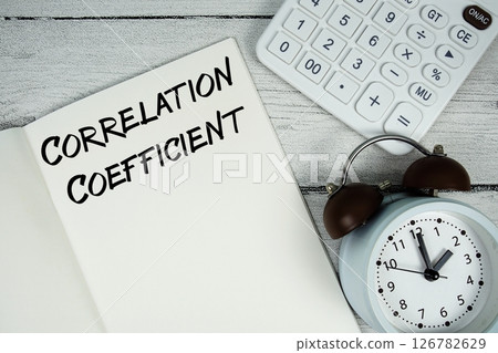 Correlation Coefficient text on paper notebook page with alarm clock and calculator on wooden background Correlation Coefficient text on paper notebook page with alarm clock and calculator on wooden background 126782629
