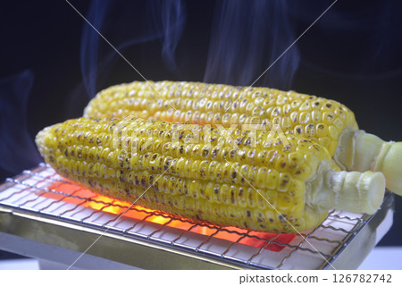 Grilling corn on a charcoal grill with rising smoke Grilling corn on a charcoal grill with rising smoke 126782742