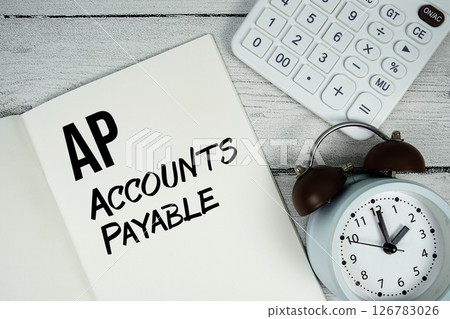 AP Accounts Payable text on paper notebook page with alarm clock and calculator on wooden background 126783026