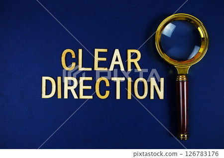 Clear Direction alphabet letters with magnifying glass on navy blue background 126783176