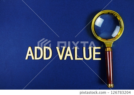Add Value alphabet letters with magnifying glass on navy blue background 126783204