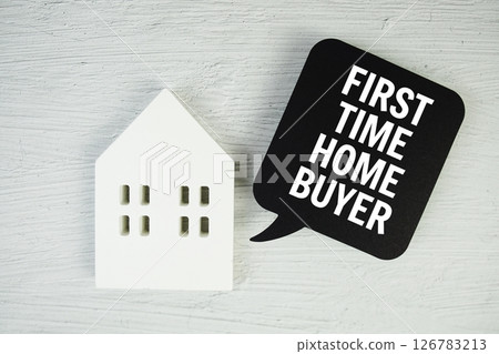 First Time Home Buyer text message on speech bubble with house model on concrete background 126783213