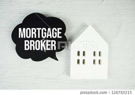 Mortgage Broker text message on speech bubble with house model on concrete background Mortgage Broker text message on speech bubble with house model on concrete background 126783215
