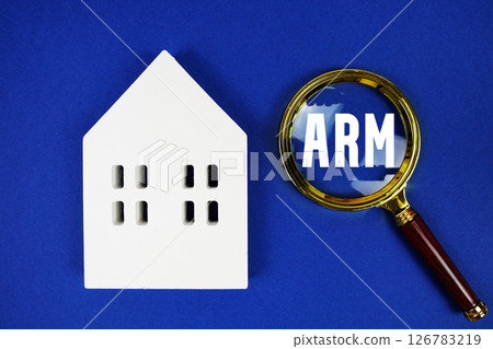 ARM abbreviation of Adjustable Rate Mortgage with house model and magnifying glass on blue background 126783219