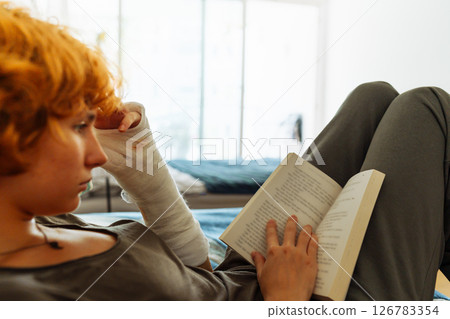 Teen girl with broken arm, red hair, in bedroom 126783354