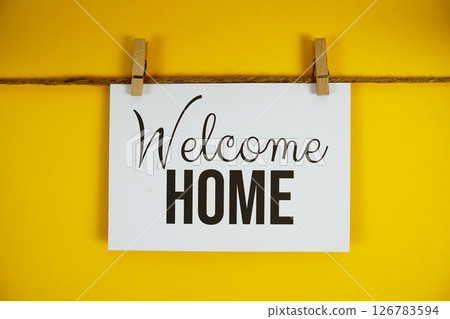 Welcome Home text on paper card on yellow background 126783594