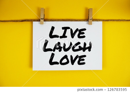 Live Laugh Love text on paper card on yellow background 126783595