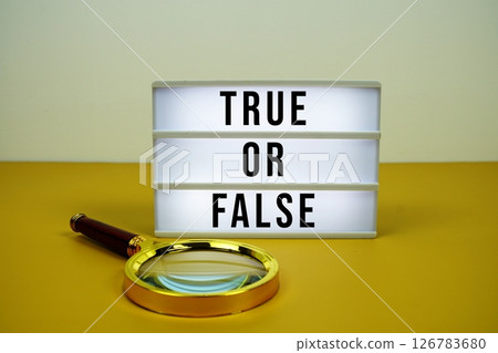 True or False text on light box with magnifying glass on yellow background True or False text on light box with magnifying glass on yellow background 126783680