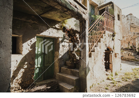 Soldier Carefully Goes Down The Stairs Of A Destroyed House Soldier Carefully Goes Down The Stairs Of A Destroyed House 126783692