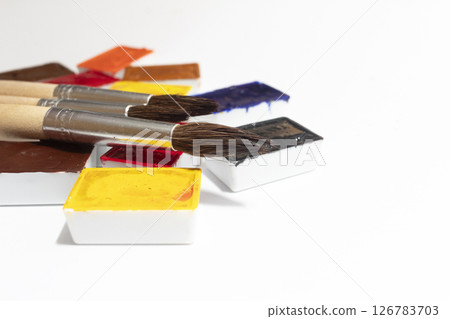 A vibrant color palette of watercolor paints with artist brushes that showcase a variety of shades and textures, perfect for art projects and creative expression A vibrant color palette of watercolor paints with artist brushes that showcase a variety of shades and textures, perfect for art projects and creative expression 126783703