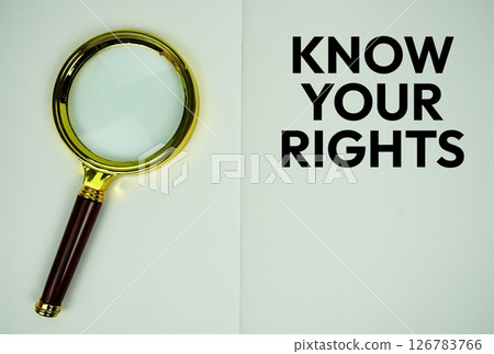 Know Your Rights text with magnifying glass flat lay on notepad background Know Your Rights text with magnifying glass flat lay on notepad background 126783766