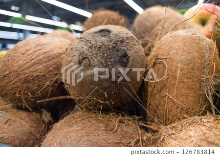 Freshly harvested coconuts gathered in a rustic market setting Freshly harvested coconuts gathered in a rustic market setting 126783814