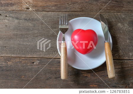 Red heart on dish and table knife and fork . 126783851