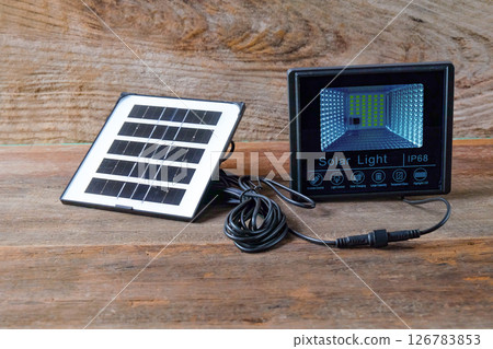 Solar lighting and solar panel on wood table ,Ecological electrical energy . Solar lighting and solar panel on wood table ,Ecological electrical energy . 126783853