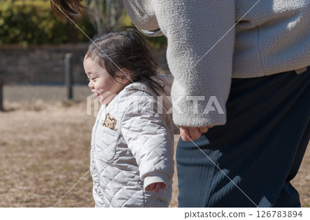 [A one-year-old child and his mother playing on the grass at Sagamihara City Asamizo Park] 126783894