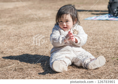 [相模原市立麻溝公園，一位一歲兒童坐在草地上玩耍] 126783901