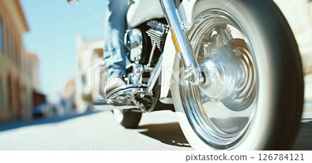 Close-up of motorcycle rear wheel in motion blur on sunny street Close-up of motorcycle rear wheel in motion blur on sunny street 126784121