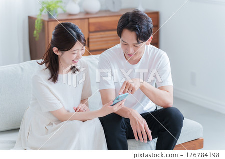 懷孕的妻子和丈夫看著智慧型手機 126784198