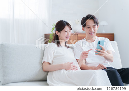懷孕的妻子和丈夫看著智慧型手機 126784199