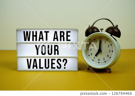 What Are Your Values? text on LED lightbox with alarm clock on yellow background 126784468