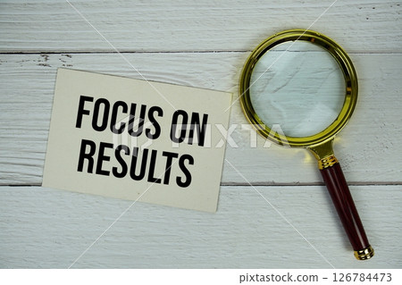 Focus On Results text on paper card with magnifying glass flat lay on wooden background Focus On Results text on paper card with magnifying glass flat lay on wooden background 126784473