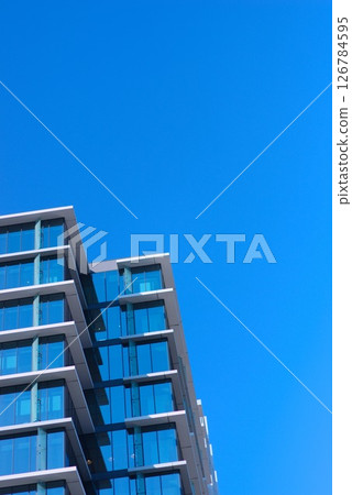 A composition of glass skyscrapers towering over a city and blue skies 126784595