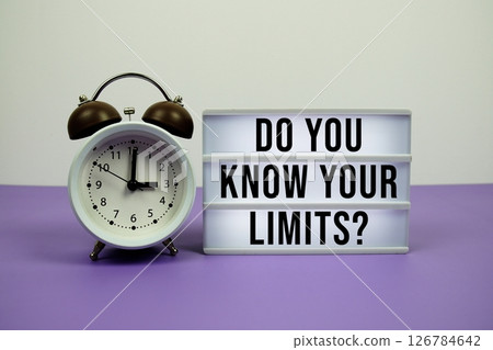 Do You Know Your Limits? text on light box with alarm clock on purple background 126784642
