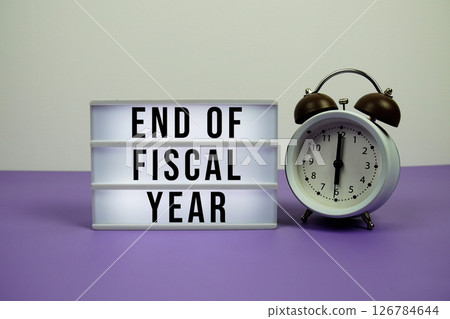 End of Fiscal Year text on light box with alarm clock on purple background 126784644