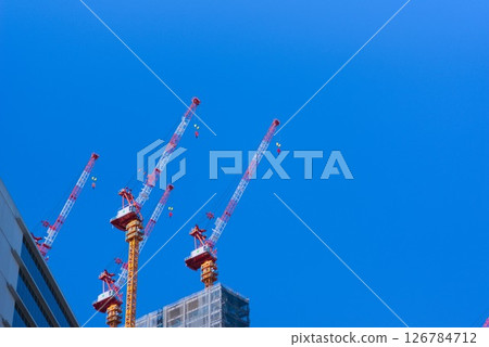 塔式起重機聳立在正在經歷建設熱潮的城市上空 126784712