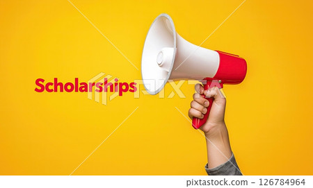 hand holding a white megaphone with a RED handle. The background is a solid YELLOW color. In the center of the image, there is a text that reads Scholarships.	 126784964