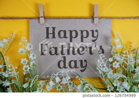 Happy Father's Day text on paper card with flower blooming decoration on yellow background 126784999