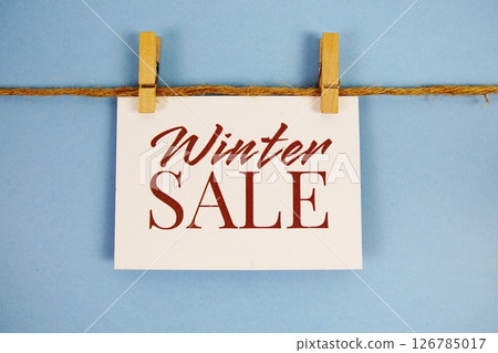 Winter Sale text on paper card on blue background 126785017