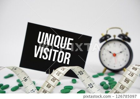 Unique Visitor text with alarm clock and measuring tape on white background Unique Visitor text with alarm clock and measuring tape on white background 126785097