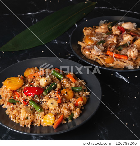 Asian Stir-Fried Rice and Noodles on Black Background 126785200