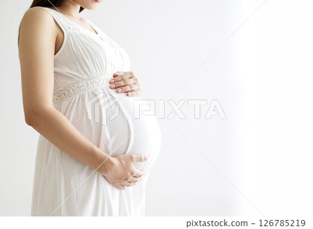 AI-generated image of a faceless pregnant woman wearing a white dress and a white background AI-generated image of a faceless pregnant woman wearing a white dress and a white background 126785219