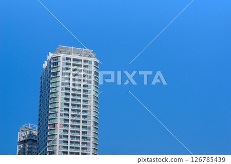 一棟高聳的塔式公寓大樓聳立在湛藍的天空上 126785439