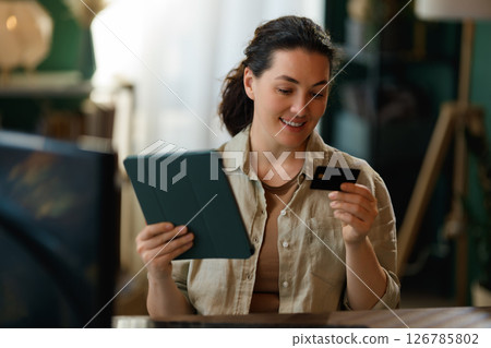 Woman is doing online purchases 126785802