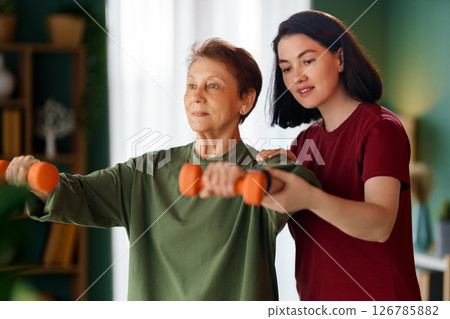 Senior woman doing dumbbell exercise 126785882