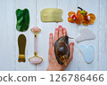Spa concept gua sha massage body and face care and snails achatina on hand, flat lay. High quality photo Spa concept gua sha massage body and face care and snails achatina on hand, flat lay. High quality photo 126786466