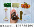 Spa concept gua sha massage body and face care and snails achatina on hand, flat lay. High quality photo Spa concept gua sha massage body and face care and snails achatina on hand, flat lay. High quality photo 126786469
