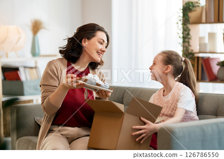 Mother and daughter are unpacking cardboard Mother and daughter are unpacking cardboard 126786550