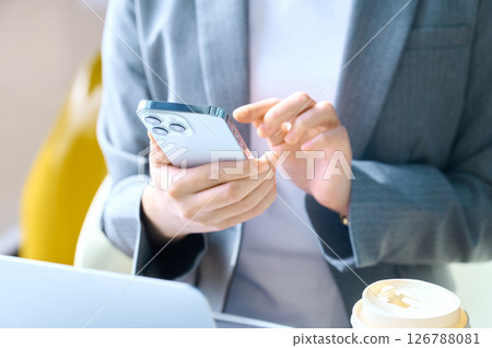 女商人操作智慧型手機。拍攝合作:SKY PerfecTV東京媒體中心 女商人操作智慧型手機。拍攝合作:SKY PerfecTV東京媒體中心 126788081