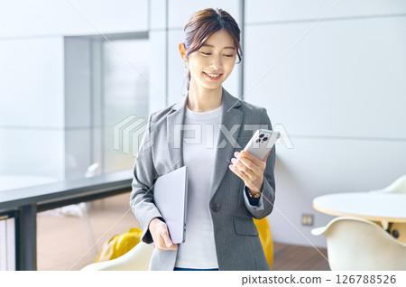 辦公室裡正在工作的年輕女商人。 辦公室裡正在工作的年輕女商人。 126788526