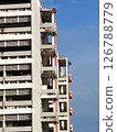 A high-rise apartment building against a blue sky. 126788779