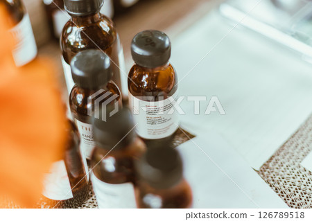 Shot of mature perfumer adding extra essential oil Shot of mature perfumer adding extra essential oil 126789518