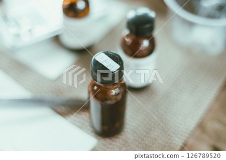 Shot of mature perfumer adding extra essential oil Shot of mature perfumer adding extra essential oil 126789520