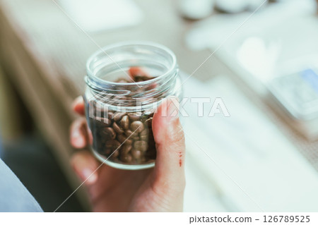Shot of mature perfumer adding extra essential oil Shot of mature perfumer adding extra essential oil 126789525