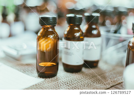 Shot of mature perfumer adding extra essential oil Shot of mature perfumer adding extra essential oil 126789527