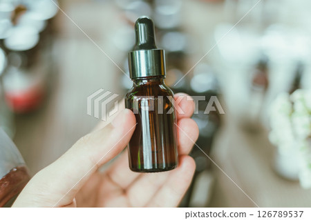 Shot of mature perfumer adding extra essential oil 126789537