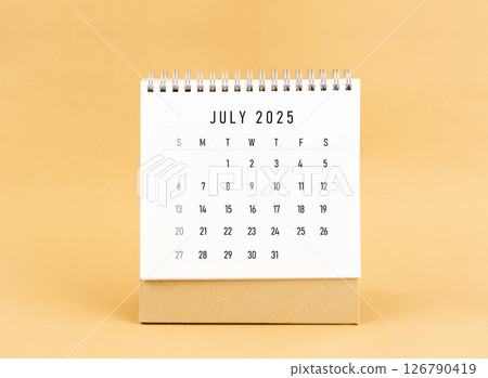 July 2025 desk calendar on yellow background, Front view. July 2025 desk calendar on yellow background, Front view. 126790419